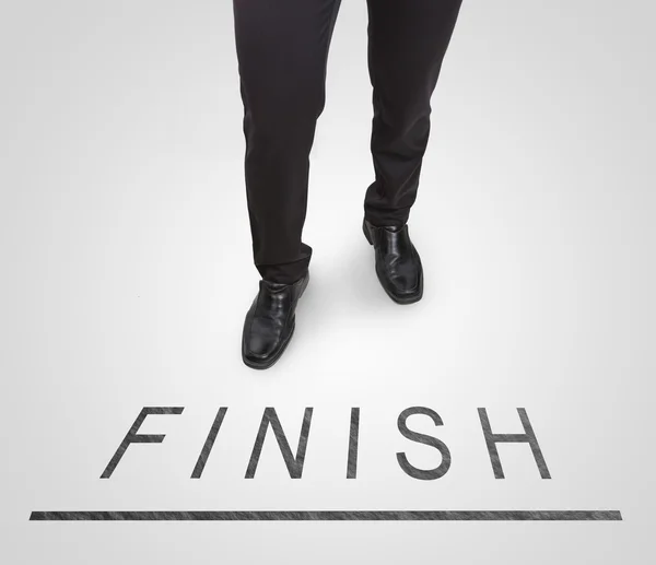 Businessman standing wearing court shoes on finish line. — Stock Photo, Image