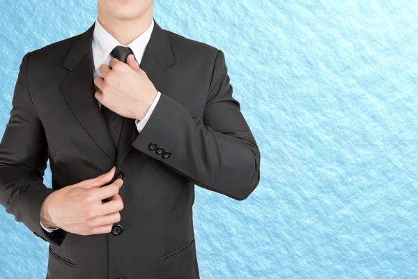 Gut gekleideter Geschäftsmann sieht aus wie smart, wenn er seine Krawatte anpasst — Stockfoto