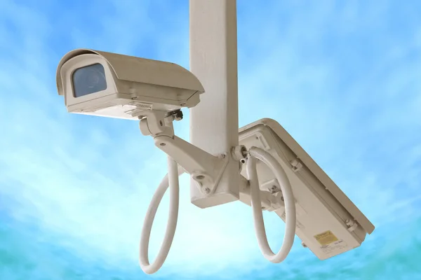 Bezpečnostní kamera dvojče izolovaných na pozadí modré oblohy. — Stock fotografie