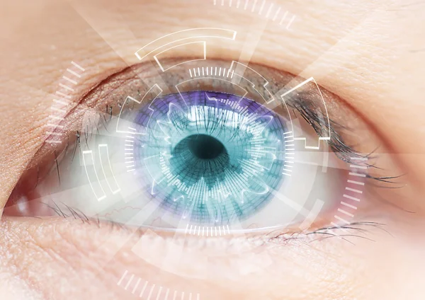 Gros plan sur les yeux bleus des femmes. Les hautes technologies dans la lentille de contact futuriste — Photo