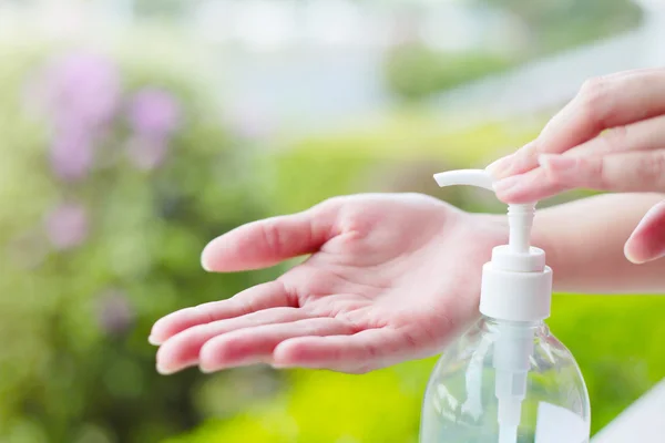 Женские руки с помощью мытья рук дезинфицирующий гель насос дозатор. — стоковое фото