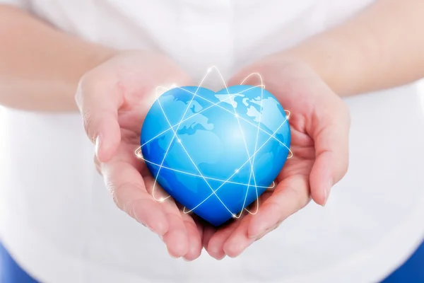 Female hands holding on earth global heart. — Stock Photo, Image