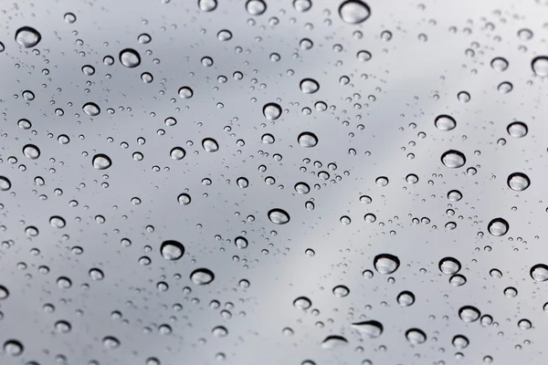 Βροχερή σταγόνα νερού σε γυάλινο καθρέφτη φόντο. — Φωτογραφία Αρχείου