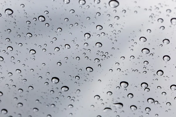 Goutte d'eau pluvieuse sur fond miroir en verre . — Photo