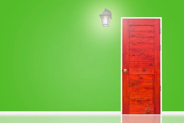 Wooden door and lamp with isolated green wall texture. — Stock Photo, Image