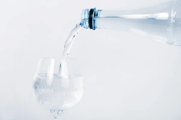 Versare acqua minerale nella bottiglia su erba pulita . — Foto Stock