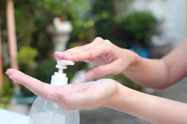 Tangan perempuan menggunakan gel pump dispenser pembersih tangan pembersih . — Stok Foto