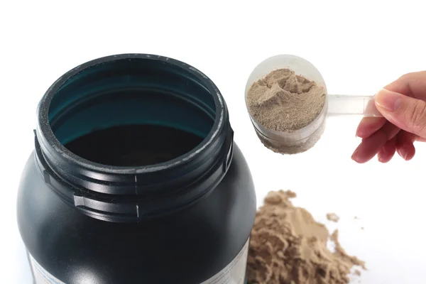 The hand raise a spoon measure Whey protein chocolate powder. — Stok fotoğraf