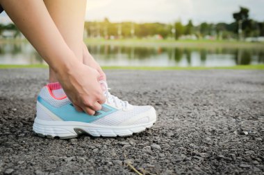 Kadın spor ayakkabı bağlama Park'ta jogging hazırlamak.