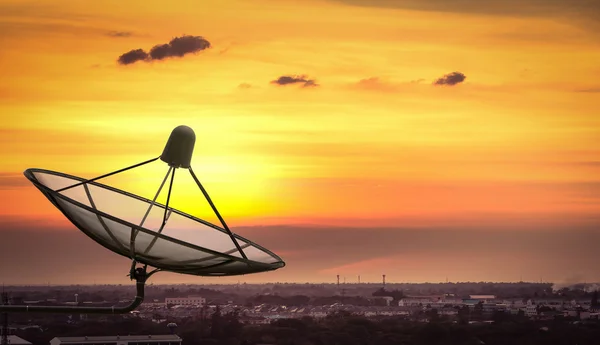 Antena parabólica na cidade ao pôr do sol . — Fotografia de Stock