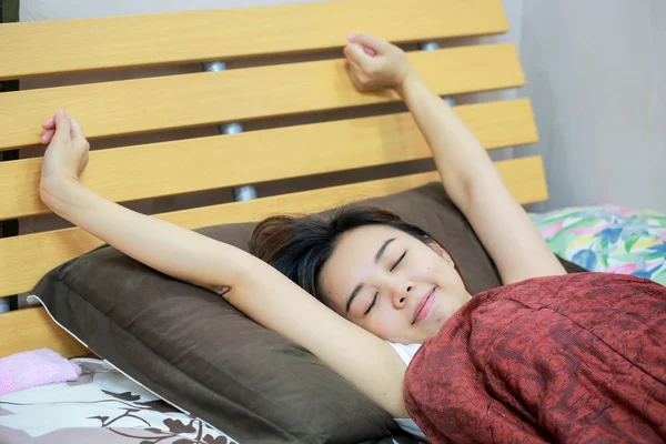 Jonge vrouwen die zich uitstrekt op bed in de ochtend. — Stockfoto