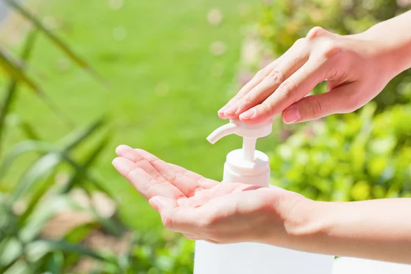 Hembra manos usando lavado de manos desinfectante gel bomba dispensador. — Foto de Stock