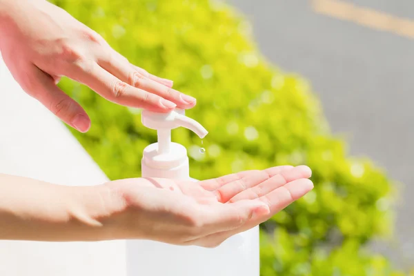 Hembra manos usando lavado de manos desinfectante gel bomba dispensador. — Foto de Stock