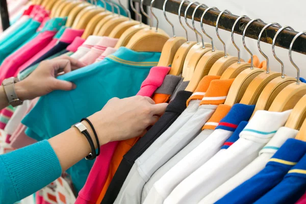 Mujer joven buscando nueva camisa de compras en la tienda . —  Fotos de Stock