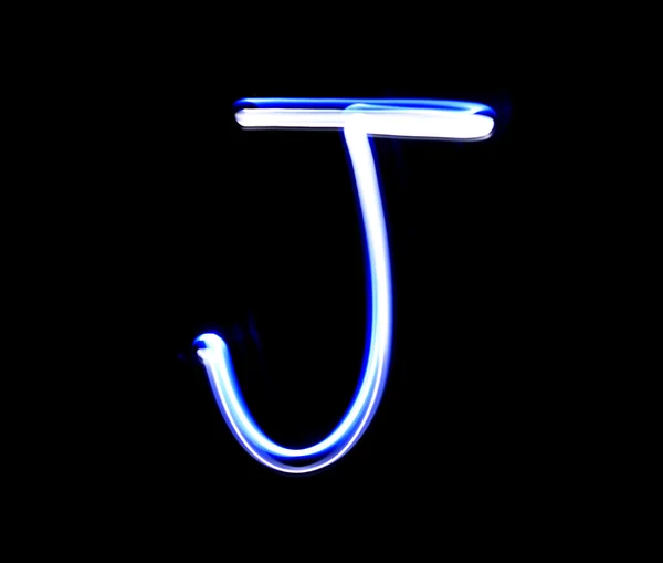 J Jimmy alphabet hand writing blue light  over black background. — Stock Photo, Image