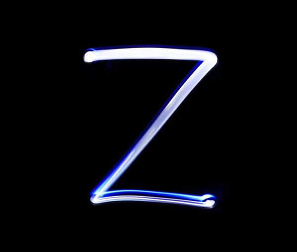 Z Zulu alphabet hand writing blue light  over black background. — Stock Photo, Image