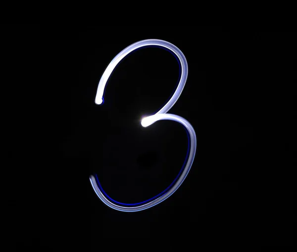 Three 3 blue light digit hand writing over black background. — Stock Photo, Image