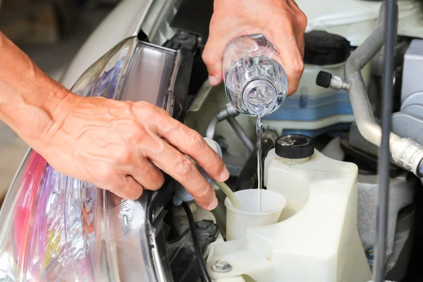 Füllen Sie die Scheibenwasserflüssigkeit an einem Auto. — Stockfoto