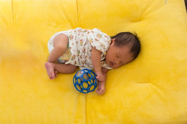 Újszülött baba alszik a sárga szőr szövet ágy. — Stock Fotó