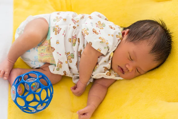 Новорожденный ребенок спит на кровати из желтого меха . — стоковое фото