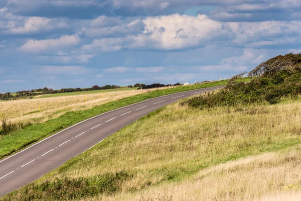Boş ülke lane fırtınalı gökyüzü altında