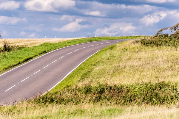Boş köy yolunda fırtınalı gökyüzü altında