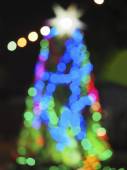 Na pozadí svítí zaostale bokeh. Modrý zelený bokeh abstraktní světelný pozadí. Barevné kruhy světelného abstraktního pozadí. Rozostřit vánoční stromek.