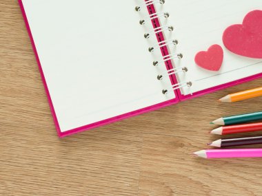 Sevgiliye arka plan kırmızı Kalpler, ahşap zemin üzerinde günlüğü ve renkli kalemler için kitap ile. Sevgi ve Sevgililer kavramı.