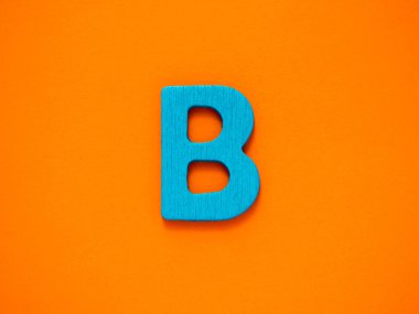 Büyük harf d. mavi mektup B ahşap turuncu zemin üzerine.