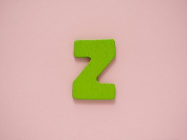 Büyük harf Z. yeşil mektup Z ahşap pembe bir arka plan üzerine.