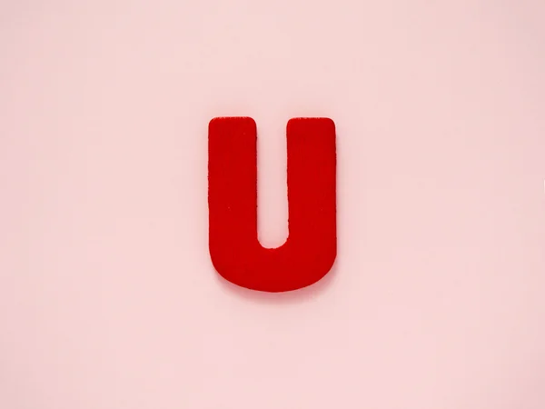 Velké písmeno U. červené písmeno U ze dřeva, na růžové pozadí. Abeceda samohláska. — Stock fotografie