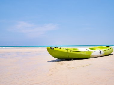 Yeşil kayık tropikal plaj arka plan ve açık mavi gökyüzü denizde teknede. Mutlu yaz tatil kavramı