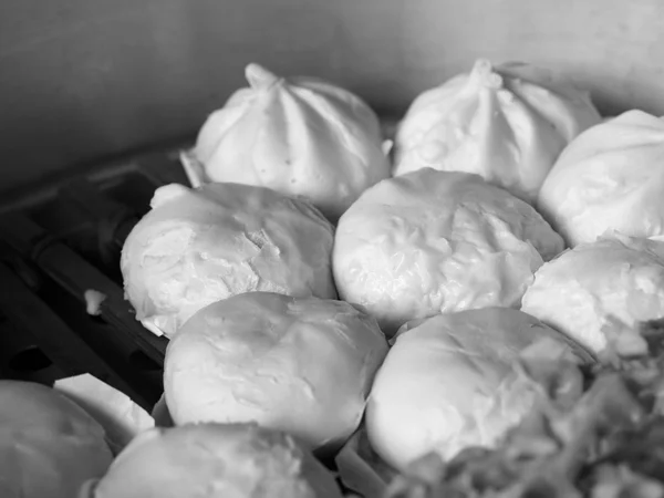 Cibo cinese locale in bianco e nero gnocchi al vapore o panini al vapore fumanti in pentola. (focus selettivo ) — Foto Stock