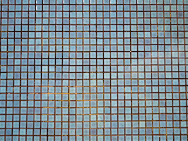 Azul rasgado água na piscina com mosaico de cerâmica em fundo — Fotografia de Stock