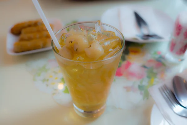 Сладкий Лонганский сок в стакане на столе для еды. Тропический сок. Фокус на Лонгане . — стоковое фото