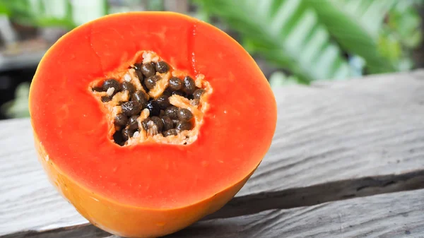 Bir buçuk Bahçe arka planda ahşap masa üzerinde taze sarı turuncu papaya