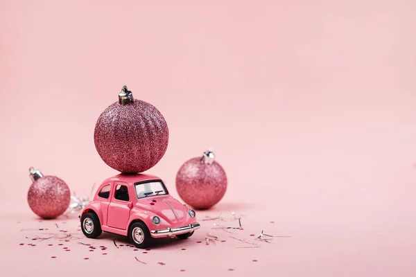 Pembe arka planda pembe bir oyuncak araba ile Noel arkaplanı kavramı