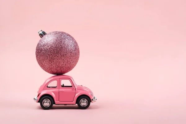 クリスマスの背景ピンクのレトロなおもちゃの車とコンセプトピンクの背景 — ストック写真