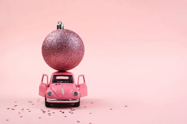 Pembe arka planda pembe bir oyuncak araba ile Noel arkaplanı kavramı
