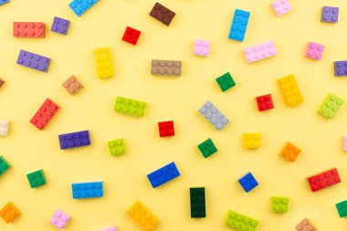 Yazmak için yeri olan renkli oyuncak tuğlalar. Oyuncak sarı arkaplan.
