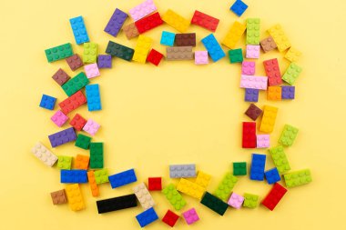 Yazmak için yeri olan renkli oyuncak tuğlalar. Oyuncak sarı arkaplan.