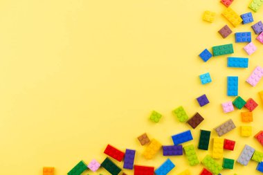 Yazmak için yeri olan renkli oyuncak tuğlalar. Oyuncak sarı arkaplan.