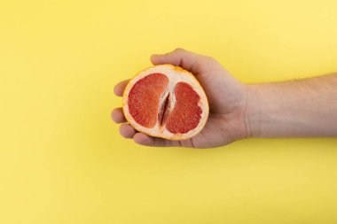 hand holds half of grapefruit clipart