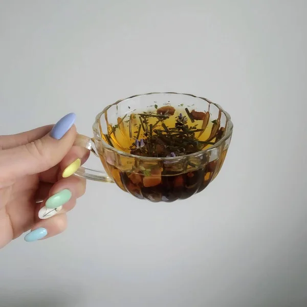 Elinde lavanta çayı olan şeffaf bir fincan.