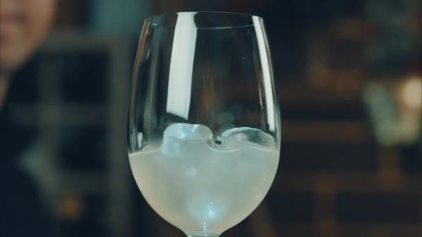 バーテンダーは、グラスに氷でレモンをスローします。 — ストック動画