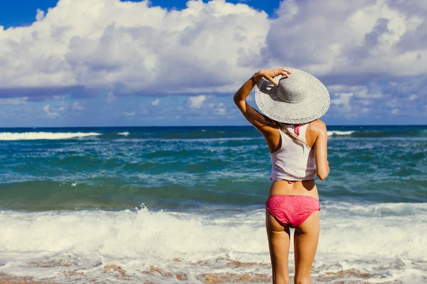 Meisje op het strand kijken naar de Oceaan, Hawaii Stockafbeelding