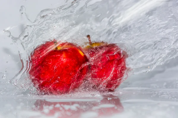 Rött äpple i vatten stänk — Stockfoto