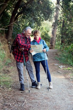 Üst düzey bir çift aktif emekliliklerinin tadını çıkarıyor, bir harita ve yürüyüş direkleriyle orman yolunda yol alıyorlar, doğada keşifleri ve sağlıklı yaşam tarzlarını birlikte kucaklıyorlar.
