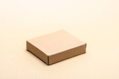 Açık bej zemin üzerinde küçük kahverengi karton kutu, izole üst görünüm modelleme ambalaj, nakliye, ticaret, hediye ve lojistik kavramlar için geniş kopya alanı