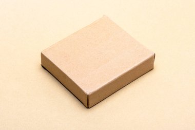 Kahverengi karton kutu bej arka planda kapanıyor, kargo, ambalaj, perakende satış ve markalaşma için temiz fotokopi alanı olan ticaret stüdyolarının genel görünümü